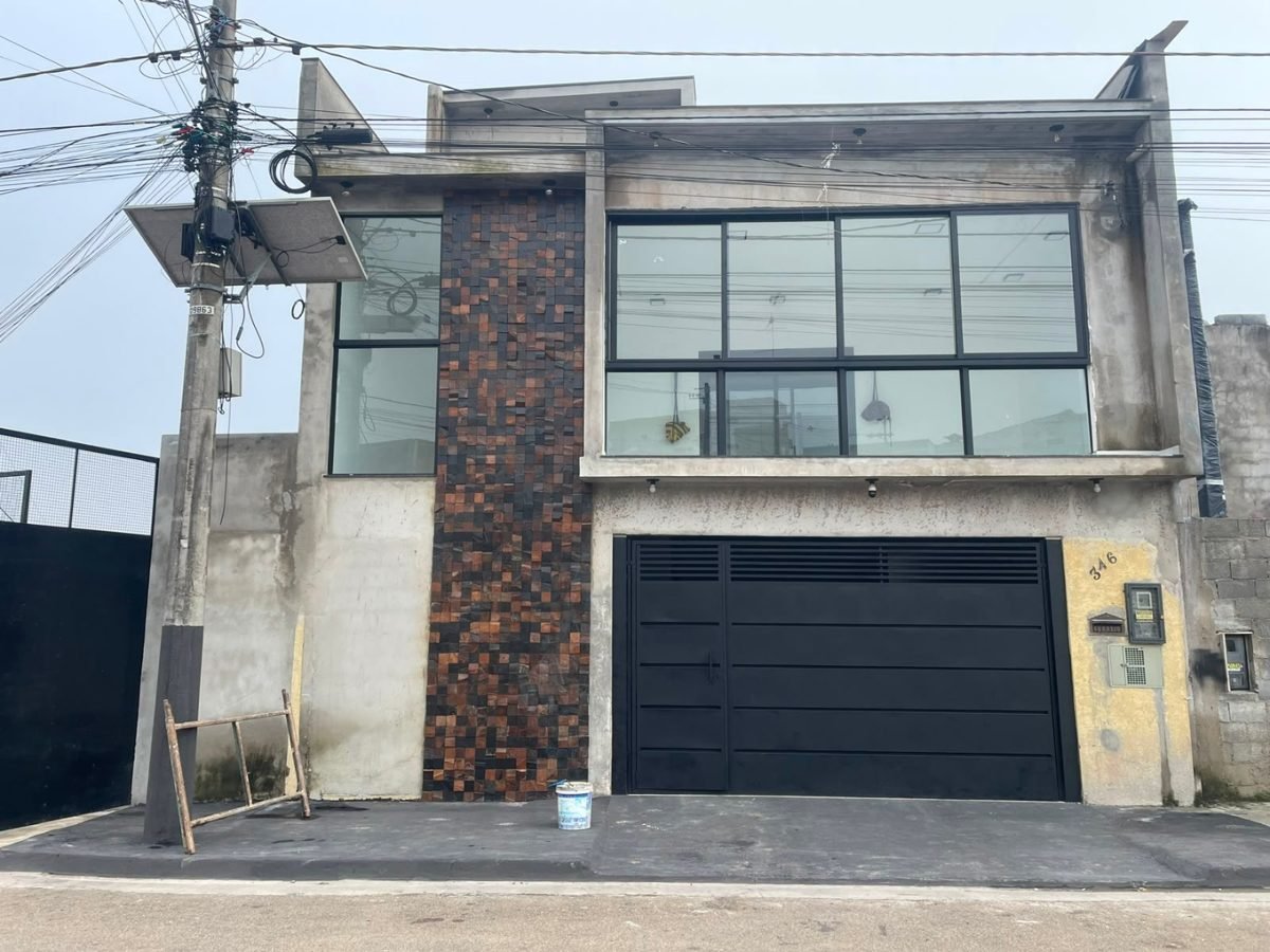 Fachada residencial antes: estrutura em concreto aparente e reboco sem pintura