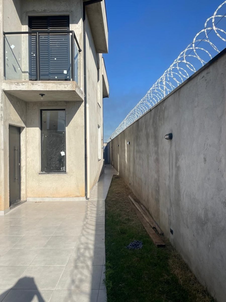 Muro perimetral antes: concreto aparente sem pintura, com cerca de segurança