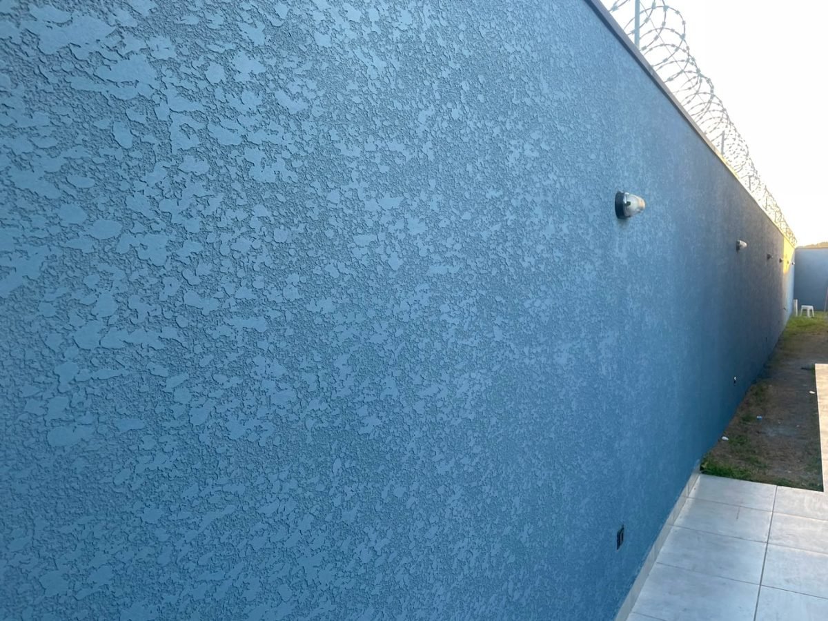 Muro perimetral depois: pintura uniforme em tom azul petróleo